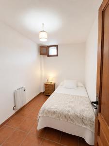 a white bedroom with a bed and a window at Capileira Luz de Sierra in Capileira