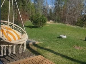 a hanging hammock in a yard with a field at Heinamaa Lodge with sauna in Lammasküla