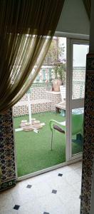 a window with a view of a patio with a chair at Dar Cherif in Kasbah