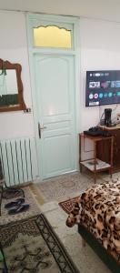 a room with a white door and a television at Dar Cherif in Kasbah +12 photos