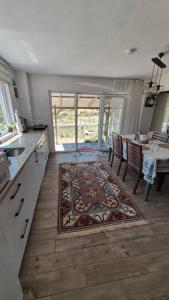 a kitchen with a table and a rug on the floor at Assos Egedebirnefes Kır Evi in Ayvacık +14 photos