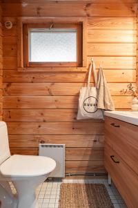 a bathroom with wooden walls and a toilet and a window at Rukan Talvihovi in Ruka +43 photos