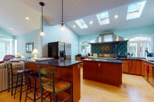 a kitchen with blue walls and a island with bar stools at Salt Pond -- 273 Oyster Shell Cove in Bethany Beach