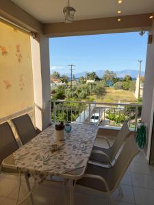 a table and chairs on a balcony with a view at Aelia Luxury Suites Melissi in Xylokastro