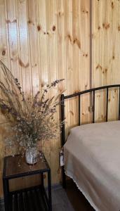 a bedroom with a bed and a vase of flowers on a table at SAOTI Guest house in Shatili