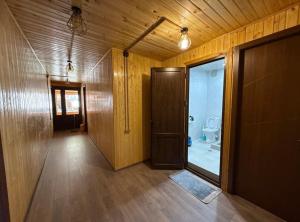 a hallway with a toilet in a room with wooden walls at SAOTI Guest house in Shatili