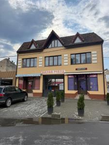 a building with a car parked in front of it at Castle View Apartments in Făgăraş