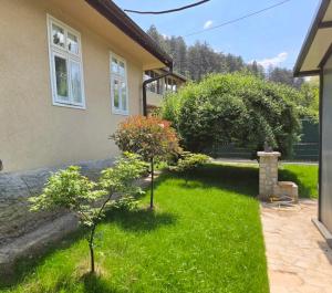 a yard with two small trees in front of a house at Kucica Yuva in Vrnjačka Banja
