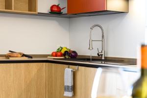a kitchen with a sink and fruits and vegetables on the counter at Sinedda Sole in San Vito lo Capo