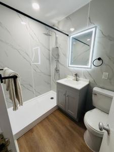 a bathroom with a shower and a sink and a toilet at AC Suites in Atlantic City +21 photos