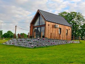 a small wooden house with a lot of pots in the grass at Mazurskie Stodoły in Piecki +41 photos