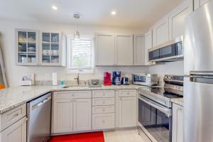 a white kitchen with white cabinets and a red rug at Bethany Pines --- 428 Bethany Pines in Bethany Beach +14 photos