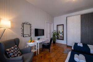 a hotel room with a bed and a desk and a tv at Selection Rooms in Belgrade
