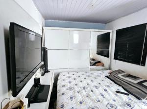 a bedroom with a bed and a flat screen tv at Condomínio top in São Paulo
