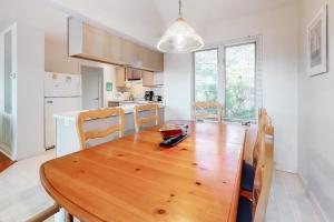 a kitchen and dining room with a wooden table and chairs at Stewards Watch -- 539C Hudson in Bethany Beach