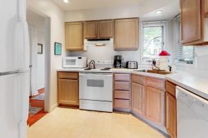 a kitchen with wooden cabinets and white appliances at Stewards Watch -- 539C Hudson in Bethany Beach