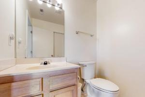 a bathroom with a toilet and a sink and a mirror at Stewards Watch -- 539C Hudson in Bethany Beach