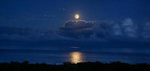 a full moon rising over the ocean at night at Vista Naranja Retreat in Santa Teresa Beach