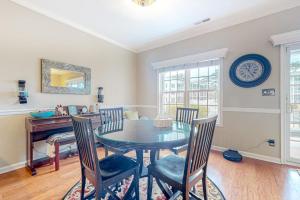 a dining room with a table and chairs and a clock at The Tides --- 19979 Sandy Bottom Circle, Unit #504 in Rehoboth Beach +23 photos