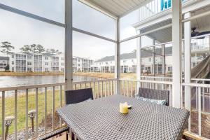 a table on a balcony with a view of the water at The Tides --- 19979 Sandy Bottom Circle, Unit #504 in Rehoboth Beach