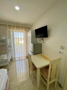 a dining room with a table and a tv on the wall at Villa Festim Ksamil in Ksamil