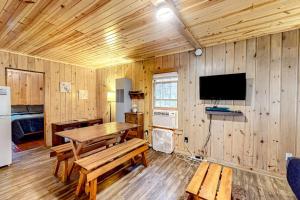 a dining room with a table and a tv in a cabin at Dragonfly Gully in Rhinelander