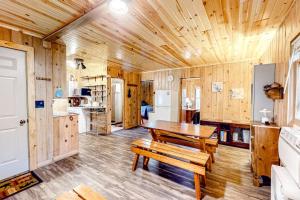 a wooden cabin with a table and a kitchen at Dragonfly Gully in Rhinelander +10 photos