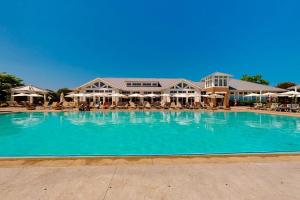 a large swimming pool with chairs and umbrellas at The Peninsula --- 22198 Dune Cir in Millsboro