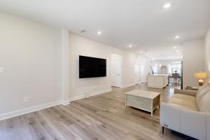 a living room with a couch and a tv on a wall at The Peninsula --- 22198 Dune Cir in Millsboro