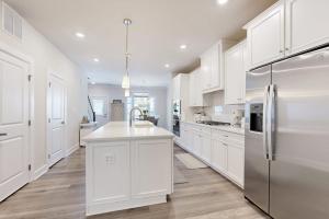a kitchen with white cabinets and a stainless steel refrigerator at The Peninsula --- 22198 Dune Cir in Millsboro +32 photos