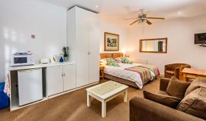 una sala de estar con una cama y un sofá en Summer Blue Guesthouse, en Port Elizabeth
