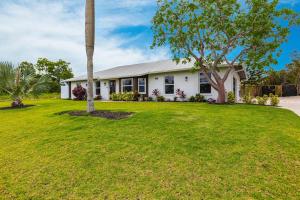a white house with a tree in a yard at Vanessas Villa in Marco Island