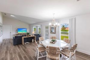 a living room with a white table and chairs at Vanessas Villa in Marco Island