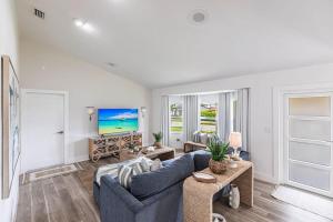 a living room with a blue couch and a tv at Vanessas Villa in Marco Island