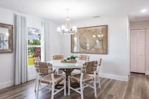a dining room with a white table and chairs at Vanessas Villa in Marco Island