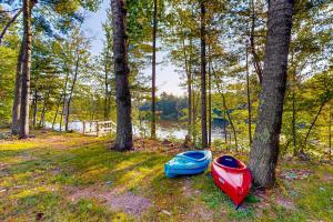 two kayaks sitting on the grass next to trees at Brown Bear Cabin in Tomahawk