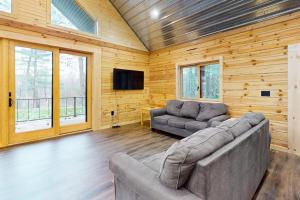 a living room with a couch and a tv at Brown Bear Cabin in Tomahawk