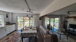 a living room with a long couch and a table at Assos Egedebirnefes Kır Evi in Ayvacık