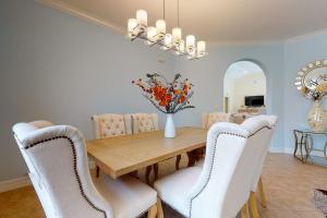 a dining room with a wooden table and white chairs at Villa Katrin in Naples