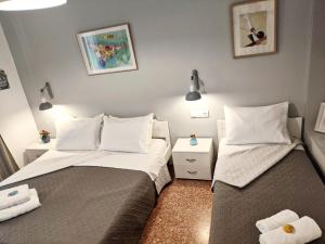 two beds in a small room with white pillows at Apartments Papadioti in Pefki