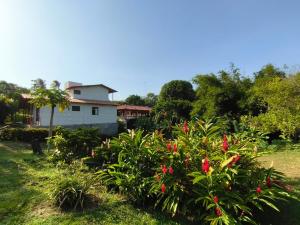 a house with a bunch of flowers in a yard at Villa Jardín Con piscina y jacuzzi in Bonda