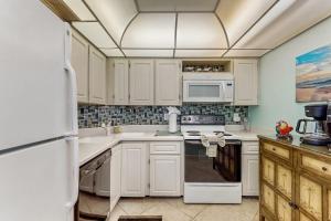 a kitchen with white cabinets and white appliances at Seaview Sunsets in Marco Island