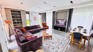 a living room with a couch and a table at Villa Maris Belek Villa in Belek