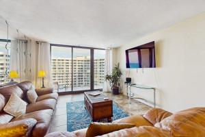 a living room with leather couches and a large window at The Breezy Perch in Marco Island
