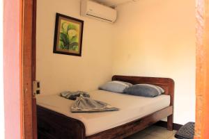 a bed with two pillows on it in a room at The Landing Hotel And Restaurant in Moyogalpa