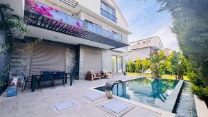 a house with a swimming pool in a yard at Villa Maris Belek Villa in Belek
