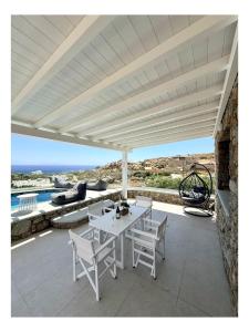 a white table and chairs on a patio at Psaros Village Mykonos in Platis Gialos