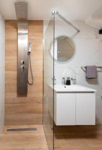 a bathroom with a shower with a sink and a mirror at United Cretan Villas Boutique Studio in Agia Marina Nea Kydonias +29 photos