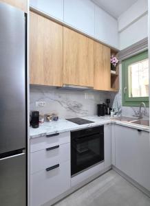 a kitchen with white cabinets and a black appliance at Mastiha Essence Residence in Pyrgi +19 photos