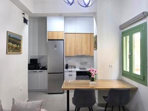 a kitchen with a table with chairs and a refrigerator at Mastiha Essence Residence in Pyrgi